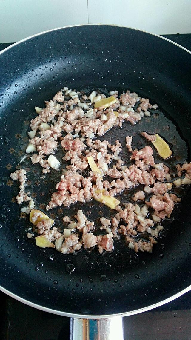 再放入猪肉末，大火将肉末炒散，之后调入适量的料酒去腥。