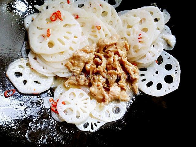 炒制两分钟的藕已熟，这时把瘦肉倒入锅内