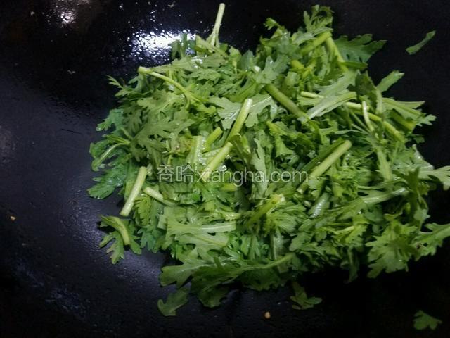 放入茼蒿翻炒，将茼蒿炒至五成熟。