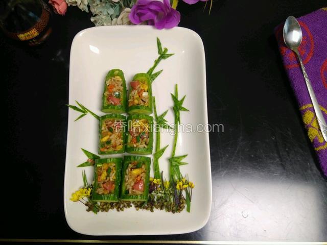 用一个小勺子把炒好的米饭装入摆好盘的黄瓜里面