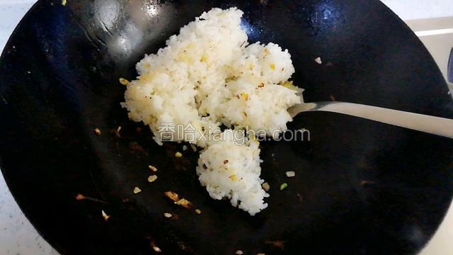 锅中倒油，放入米饭，煸炒。淋入少许水，盖上锅盖焖一分钟。