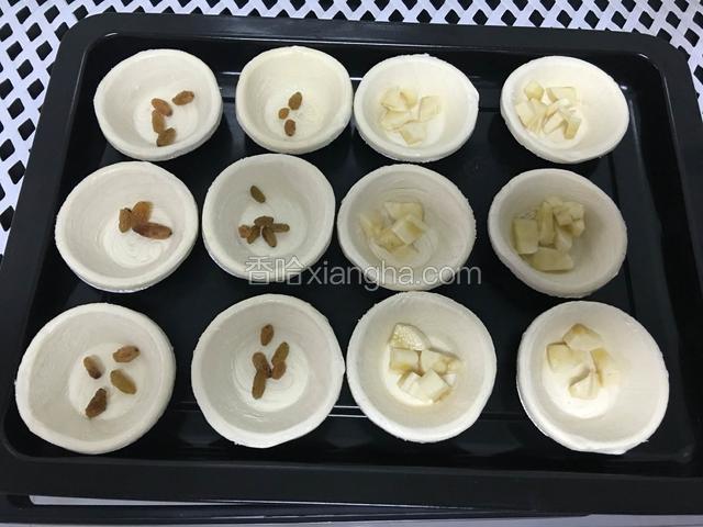 蛋挞里面放入洗干净的葡萄干和香蕉丁，喜欢什么可以自己加
