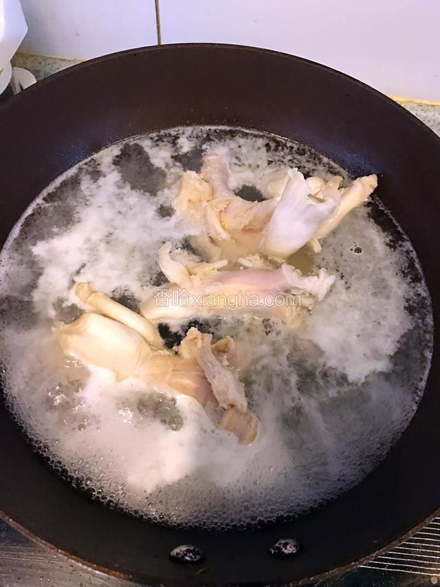 锅内加水煮沸后倒入蹄筋，变色浮出血沫，捞起后再用温水洗净盛出