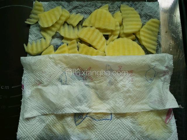 将土豆片清洗一遍后，用厨房纸擦去水分。