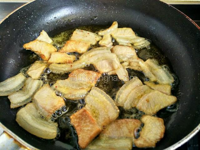 将五花肉的油逼出来，煎至两面焦黄色。