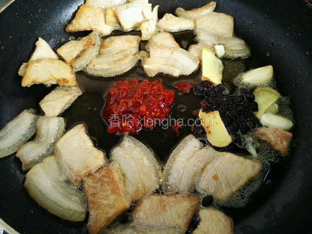 找一块空地，放入生姜蒜头，豆瓣酱和豆豉，煸香，豆瓣酱出红油。
