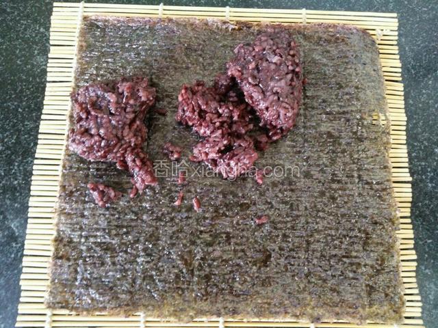 然后将黑米饭放在海苔上