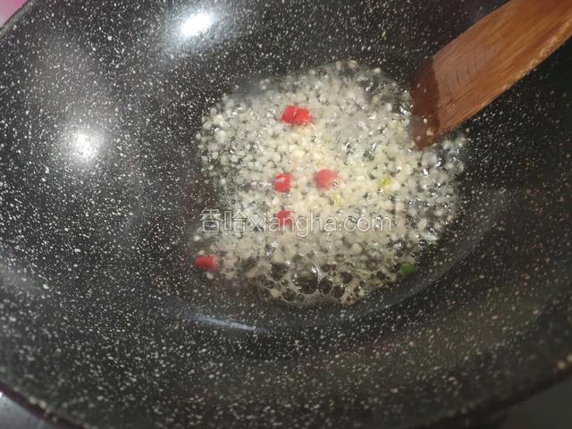 开油锅烧烫，放入红辣椒，大蒜末煸一下，加水